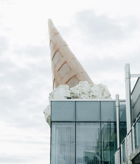 Überdimensional großes Eis steht auf dem Kopf auf einem Gebäude am Neumarkt in Köln